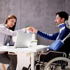 Attorney shaking hands with an injured man in a wheelchair for a Louisiana injury claim