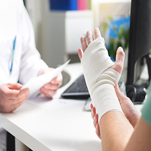 Bandaged hand at a doctor's office; legal advice on how prior injuries impact Louisiana accident claims.